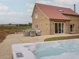 An outdoor area with a hot tub and seating at Foxes Den in Pendomer near Yeovil, Somerset