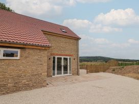An exterior view of a house with a patio and sliding doors at Foxes Den, Pendomer near Yeovil, Somerset