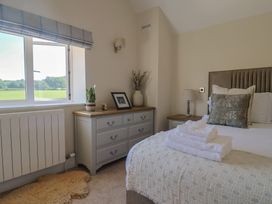 A bedroom with a bed, dresser and window at The Fox Den in East Coker
