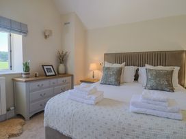 A bedroom with a bed and dresser at The Fox Den in East Coker