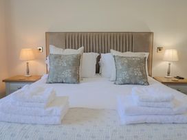 A bedroom with a bed, pillows, towels, and bedside lamps at The Fox Den in East Coker