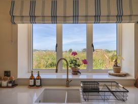 A kitchen with a window and dishes available at The Fox Den in East Coker