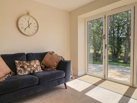 A snug with a sofa and clock at The Fox Den in East Coker