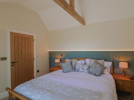 A bedroom with a bed and bedside table at The Fox Den in East Coker