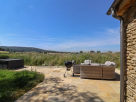 An outdoor area with a sofa and barbecue grill at The Fox Den in East Coker