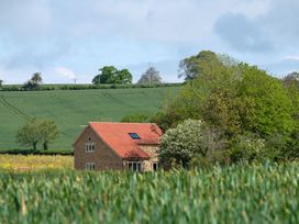A house in a field with trees at The Fox Den East Coker