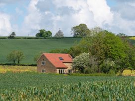 A house surrounded by fields and trees at The Fox Den in East Coker