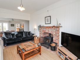 A living room with a sofa and fireplace at 4 bed in Anglesey