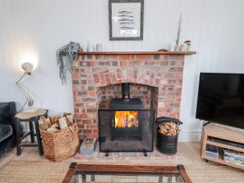 A living room with a fireplace and television at 4 bed in Anglesey