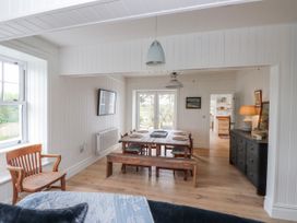 A dining room with a table, chairs and a television at 4 bed in Anglesey
