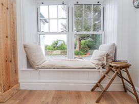 A window seat with cushions and a small stool at 4 bed in Anglesey