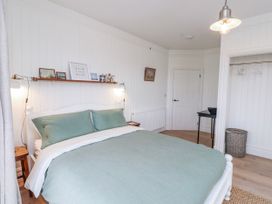 A bedroom with a bed and bedside table at 4 bed in Anglesey