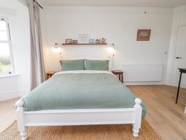 A bedroom with a bed and shelf at 4 bed in Anglesey