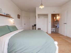 A bedroom with a bed and bathroom access at 4 bed in Anglesey