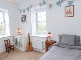 A bedroom with a bed, guitar, and a lamp at 4 bed in Anglesey
