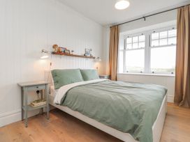 A bedroom with a bed and bedside table at 4 bed in Anglesey