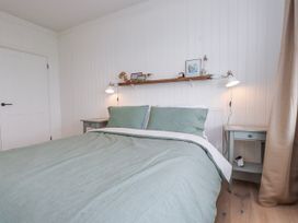 A bedroom with a bed and nightstands at 4 bed in Anglesey