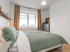 A bedroom with a bed and curtains at 4 bed in Anglesey