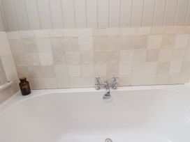 A bathtub with a faucet and bottles at 4 bed in Anglesey