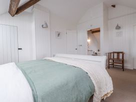 A bedroom with a bed and a chair at 4 bed in Anglesey