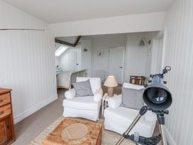 A sitting room with a telescope and light colored furniture at 4 bed in Anglesey