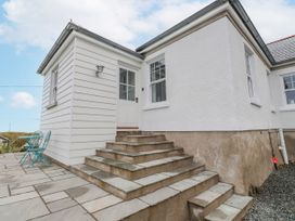 A house exterior with steps leading to a door and outdoor seating at 4 bed in Anglesey