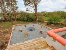 A garden area with a fire pit and tree stumps at 4 bed in Anglesey