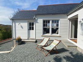 A house with two deck chairs and a gravel area at Arfryn 