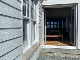 A doorway leading to a dining room with a wooden table at Arfryn Bull Bay