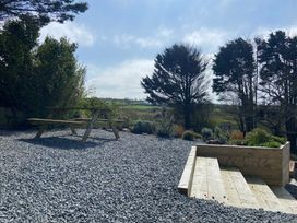 A garden with a picnic bench and gravel at Arfryn Bull Bay