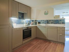 A kitchen with cabinets, oven, microwave, and sink at FLAT 3 54a broad Street (2 bed sleeping 4) Lyme Regis