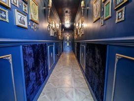 A hallway with framed art and a door at The Hollow in Holywell