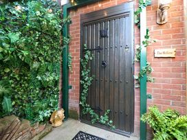 An entrance door surrounded by greenery at The Hollow in Holywell