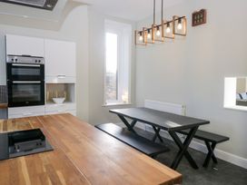 A kitchen with oven and dining table at Rocklands in Shap