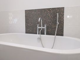 A bathtub with a faucet and showerhead at Rocklands in Shap