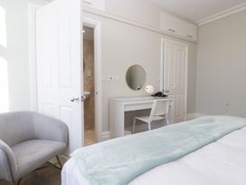 A bedroom with a desk and chair and a bathroom door at Rocklands in Shap