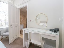 A room with a desk and chair leading to a bathroom at Rocklands in Shap