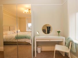 A bedroom with a bed, mirror, desk, and chair at Rocklands in Shap