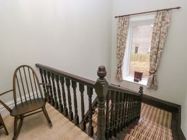 A staircase with a chair and window at Rocklands in Shap