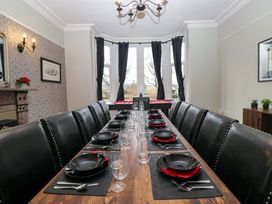 A dining room with a long table set for a meal at Rocklands in Shap