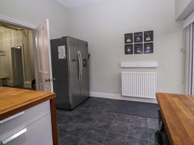 A kitchen with a refrigerator and wall art at Rocklands in Shap