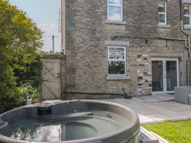 An outdoor area with a hot tub and stone wall at Rocklands in Shap