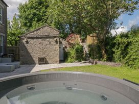 A garden with a hot tub and stone building at Rocklands in Shap