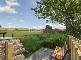 A garden with a bench and stone wall at Rocklands in Shap