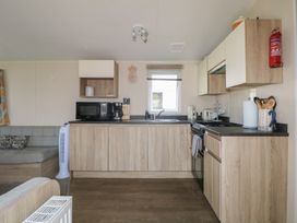 A kitchen with appliances and a sofa at Tower View Number 34 Pevensey