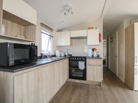 A kitchen with a stove and microwave at Tower View Number 34 Pevensey