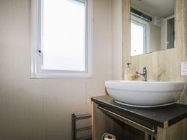 A bathroom with a sink and mirror at Tower View Number 34 in Pevensey