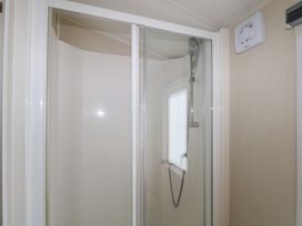 A shower with glass doors at Tower View Number 34 Pevensey