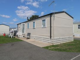 A mobile home with chairs on the patio at Tower View Number 34 Pevensey