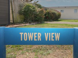 A sign reading Tower View in a garden area at Tower View Number 34 Pevensey